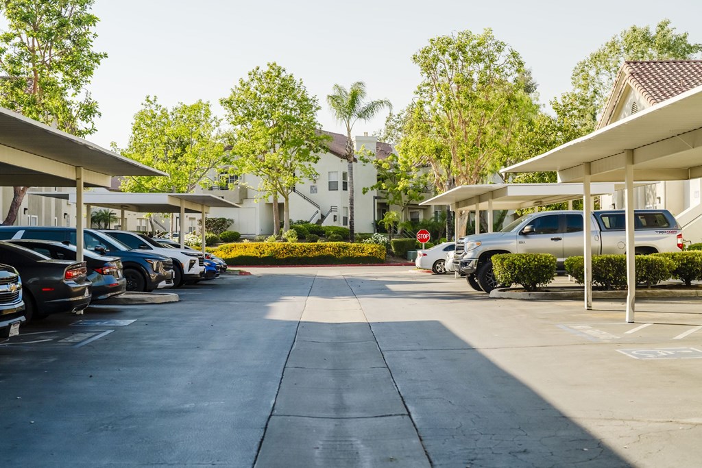 A parking lot with cars parked under a shelter. at Legends at Rancho Belago, Moreno Valley