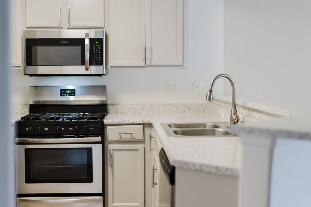 A modern kitchen with a stove, oven, microwave, and sink. at Legends at Rancho Belago, California