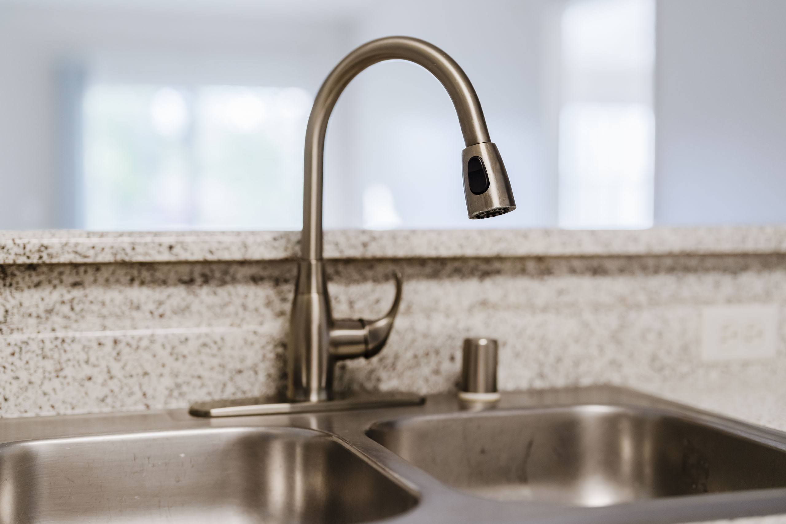 A kitchen sink with a chrome faucet.