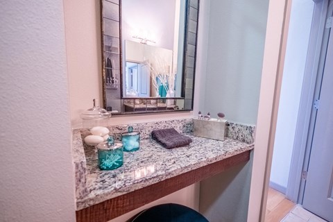 a bathroom with a granite counter top and a mirror at Azul Baldwin Park, Florida