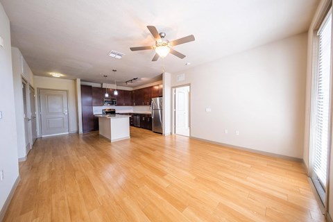 an empty living room and kitchen with wood flooring and a ceiling fan at Azul Baldwin Park, Florida