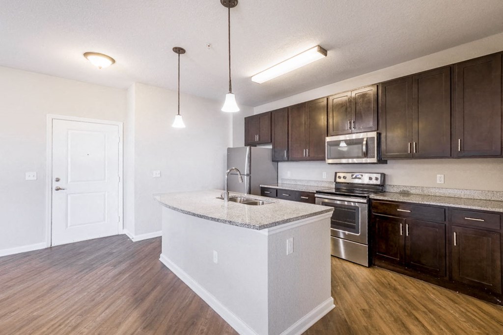 a kitchen with an island and a stove and a microwave at Linden on the GreeneWay, Orlando, 32824
