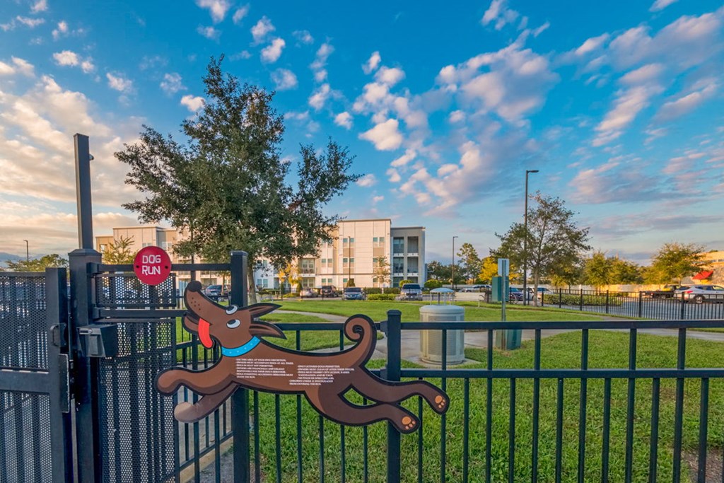 a park with a bench and a fence with a building in the background at Linden on the GreeneWay, Florida