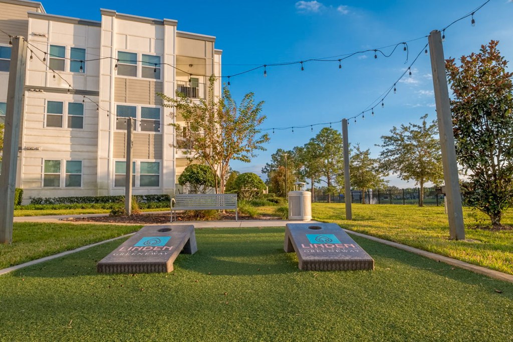 two benches in the grass in front of an apartment building at Linden on the GreeneWay, Orlando, 32824