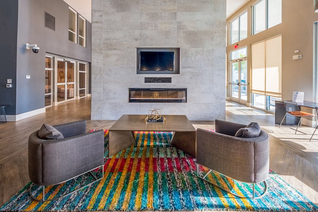 a living room with couches and a table and a fireplace at Linden on the GreeneWay, Florida, 32824