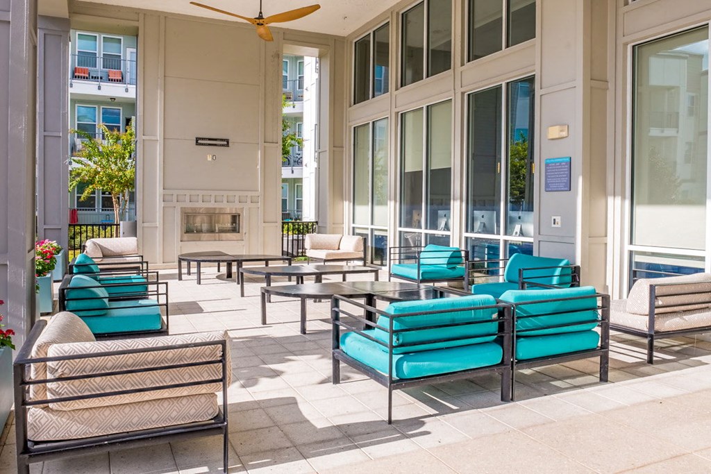 a patio with blue chairs and tables outside of a building at Linden on the GreeneWay, Orlando