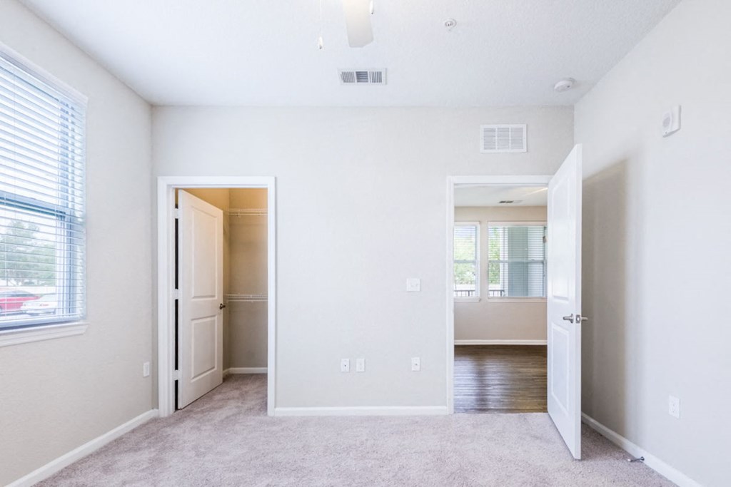 an empty bedroom with a door to a hallway and a closet at Linden on the GreeneWay, Orlando, 32824