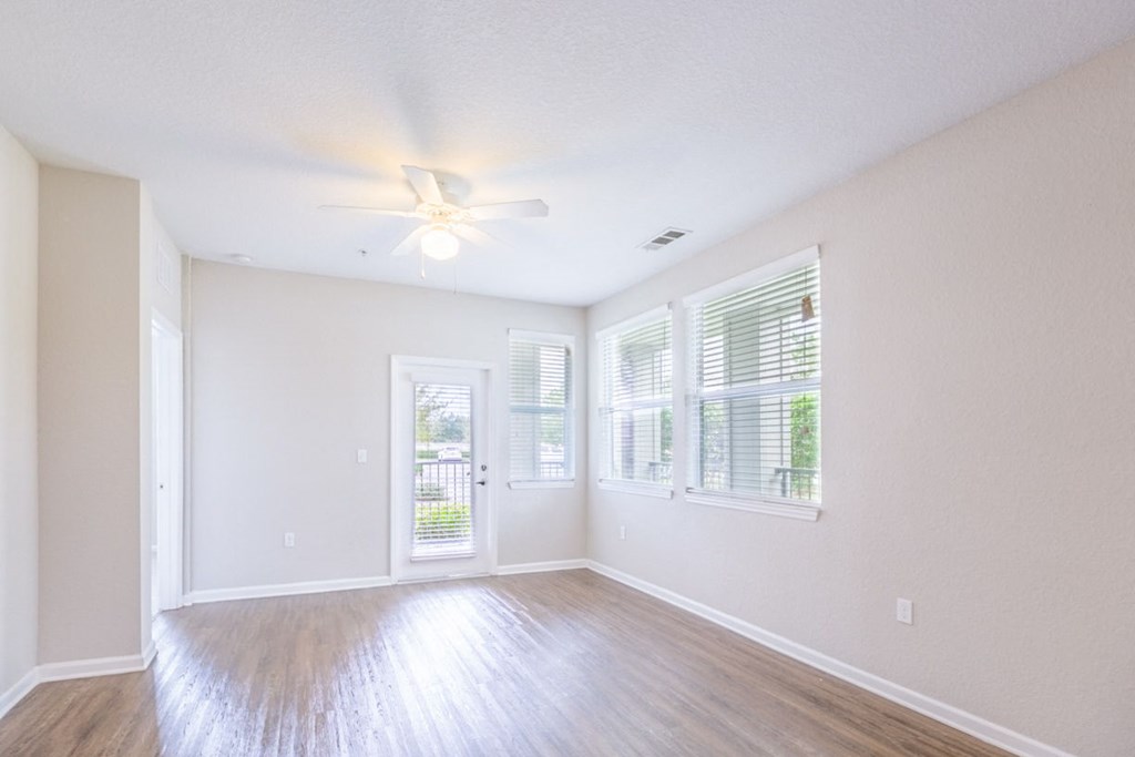 an empty living room with windows and a ceiling fan at Linden on the GreeneWay, Florida, 32824