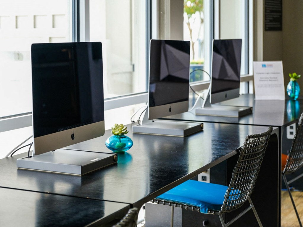 a large desk with computer monitors and chairs at Linden on the GreeneWay, Orlando, 32824