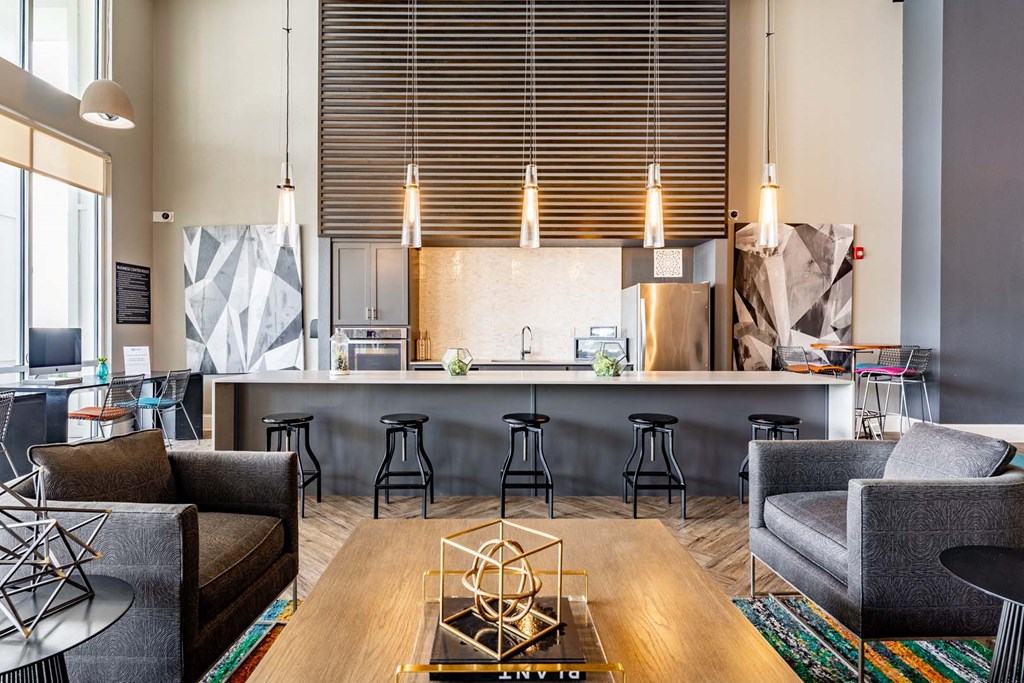 a living room with a kitchen and a table with chairs at Linden on the GreeneWay, Orlando