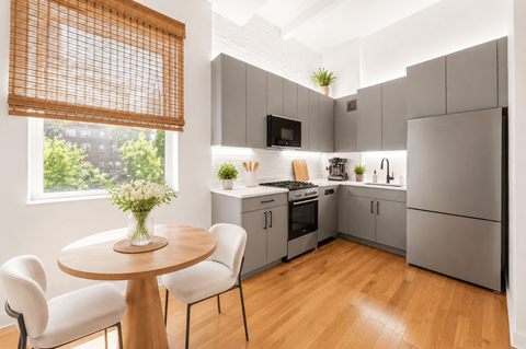 A modern kitchen with a round table and chairs.