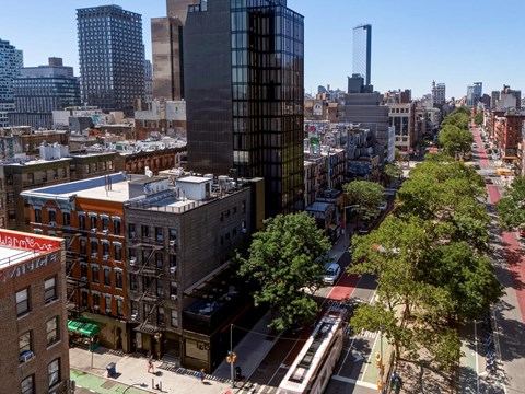 A city street with a bus and buildings on either side.