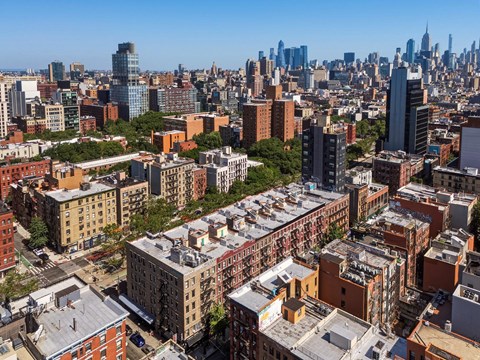 A cityscape with a mix of modern and older buildings under a clear sky.