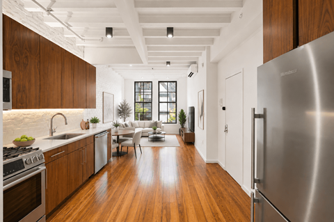 A modern kitchen with wooden cabinets and a stainless steel refrigerator.