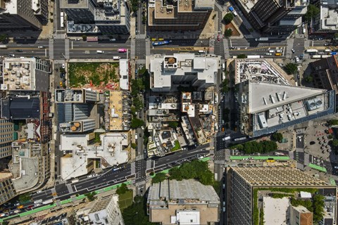 A bird's eye view of a city with buildings, roads, and green spaces.