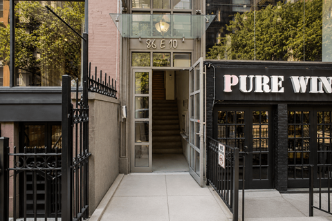 A black gate blocks the entrance to a building with a Pure Wine sign.