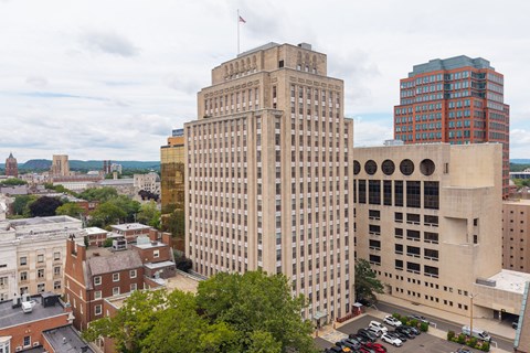 A cityscape with a large building in the center and a flag on top.
