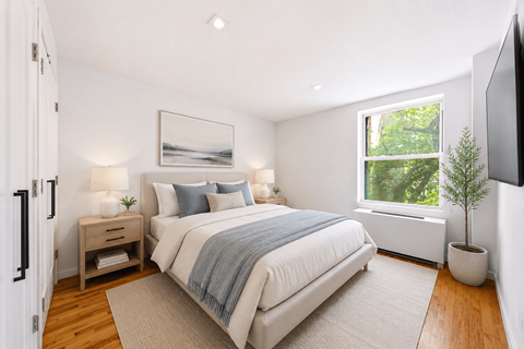 A bedroom with a large bed and a painting on the wall.