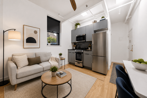 A modern kitchen with a refrigerator, oven, and microwave.