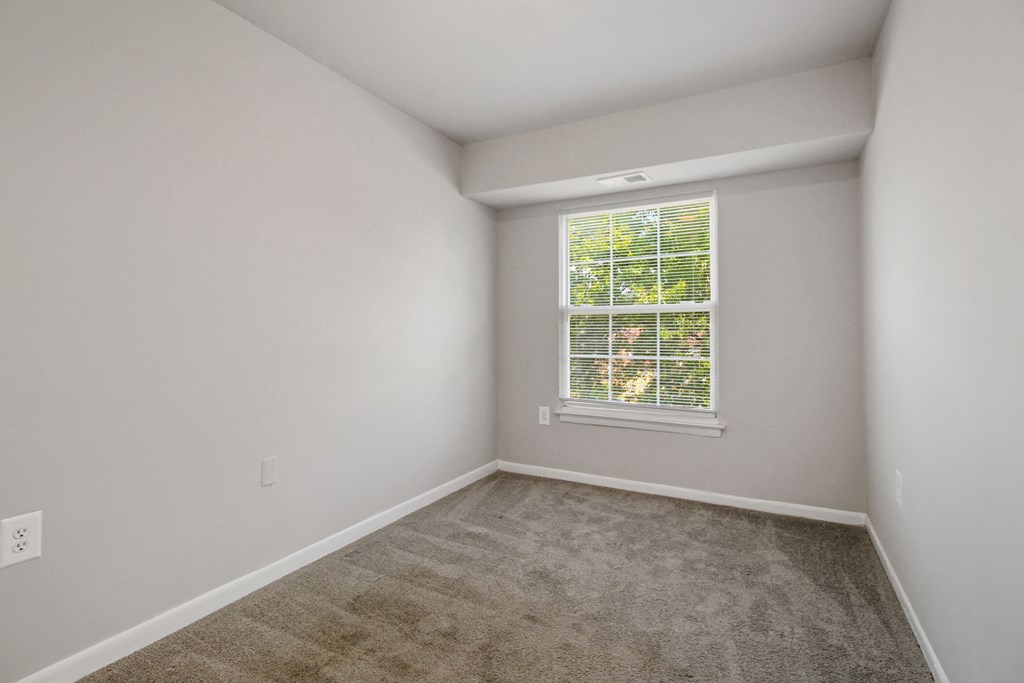 an empty room with carpet and a window