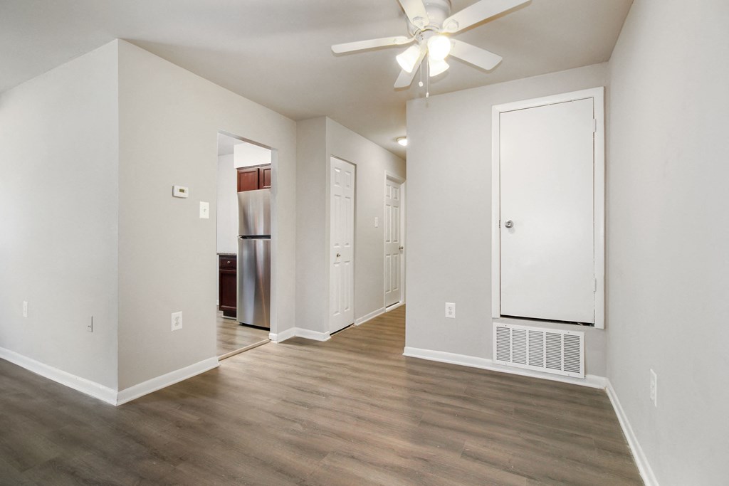 an empty living room with wood flooring and a ceiling fan