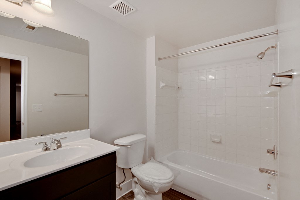 a bathroom with a sink toilet and tub and a mirror