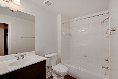 a bathroom with a sink toilet and tub and a mirror