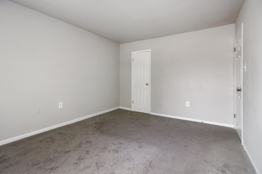 an empty room with carpet and a white door