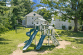 a playground in a park with a house in the background