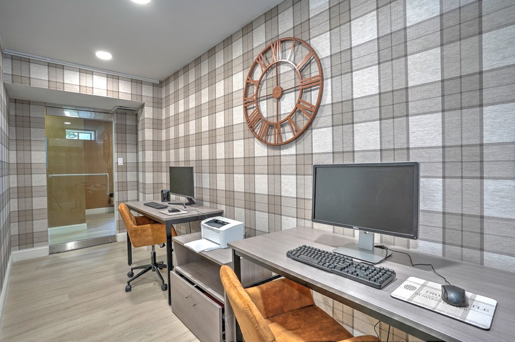 a home office with a computer and a clock on the wall