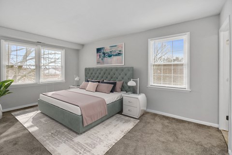 a bedroom with a bed and two windows