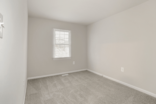 an empty room with white walls and a window