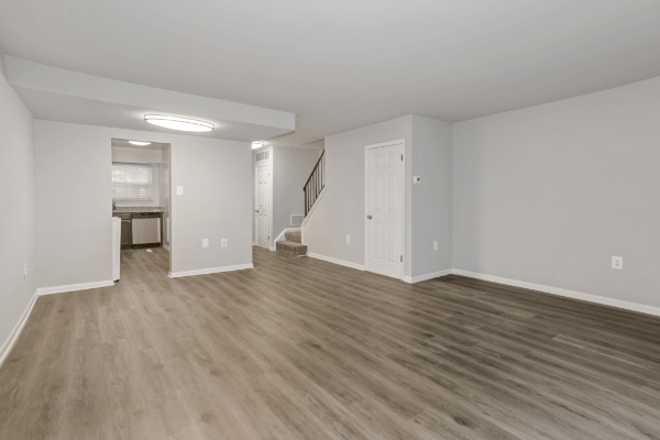 an empty living room with white walls and wood flooring