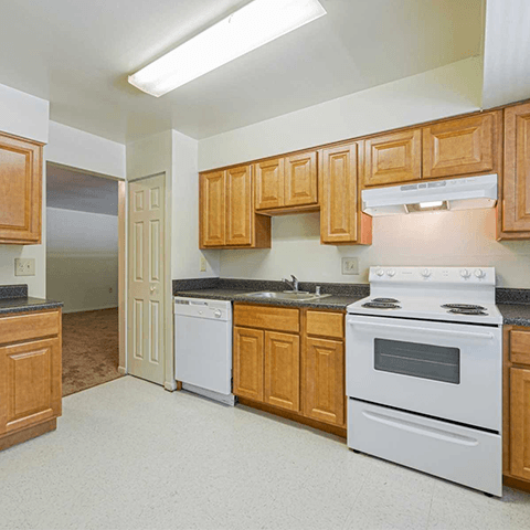 a kitchen with white appliances and wooden cabinets