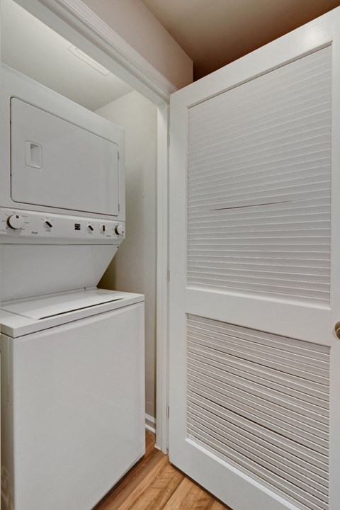 a laundry room with a refrigerator and a washer and dryer