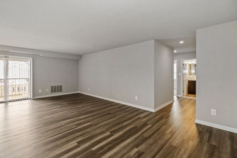 the living room and dining room of an empty house with wood flooring
