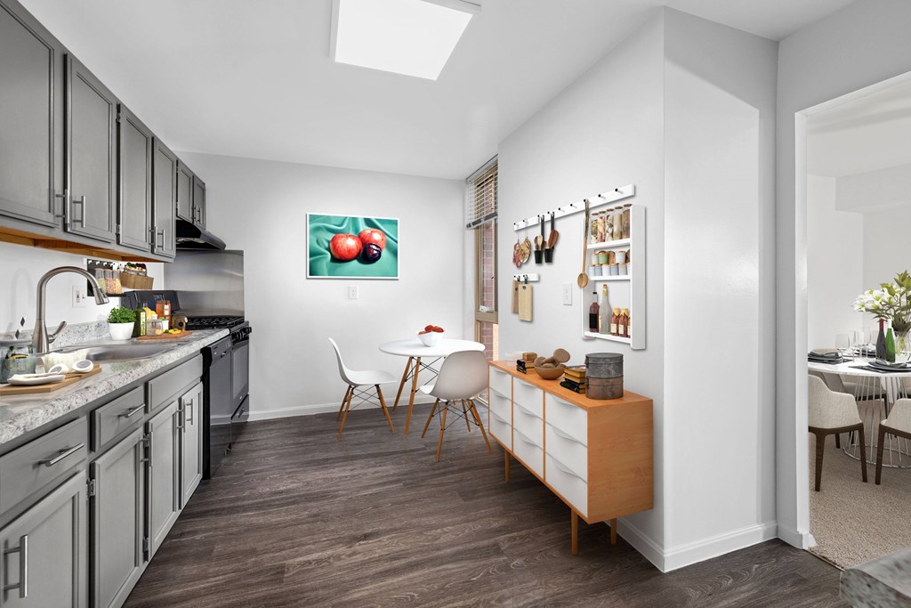 A kitchen with a dining table and chairs.
