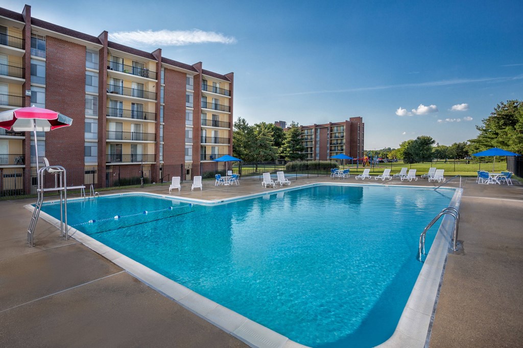 A large swimming pool in front of a brick building.