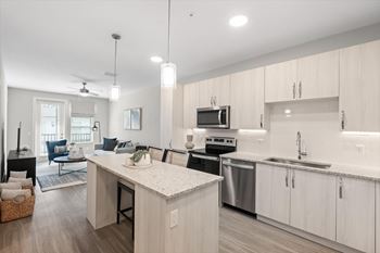 A modern kitchen with island  and enhanced cabinetry at Mira at Palmer Ranch, Florida