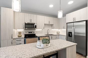 A kitchen with a granite countertop and stainless steel appliances. at Mira at Palmer Ranch, Florida, 34238