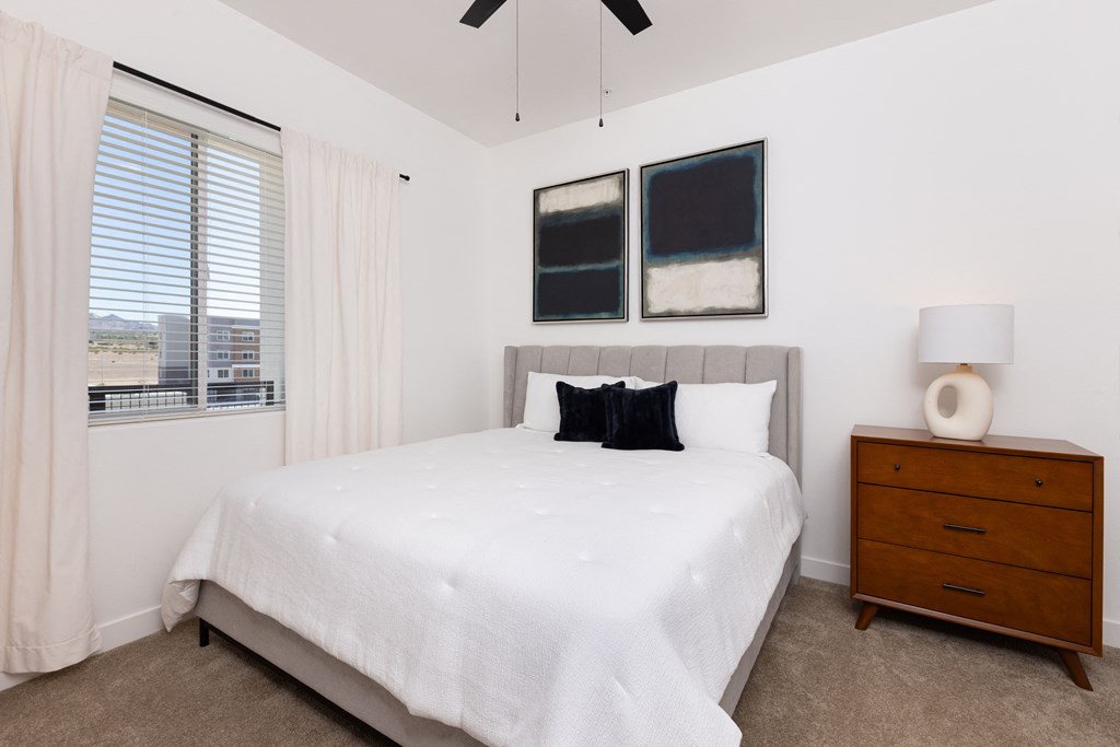 model apartment bedroom with  a bed and a ceiling fan