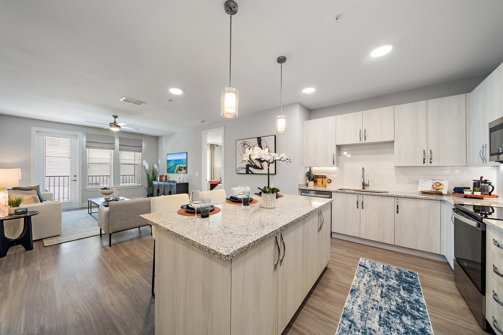 A modern kitchen with a large island and a dining area. at Mira at Palmer Ranch, Sarasota, FL