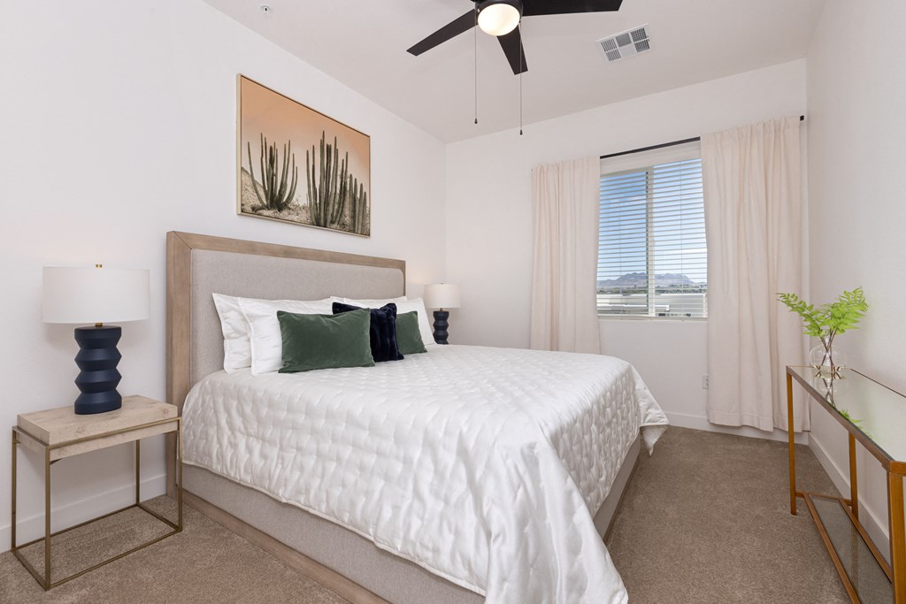 a bedroom with a large bed and a ceiling fan