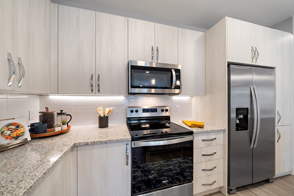 A modern kitchen with a stove, oven, refrigerator, and microwave. at Mira at Palmer Ranch, Florida, 34238