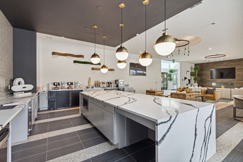 a kitchen with a large island and a dining room with chairs