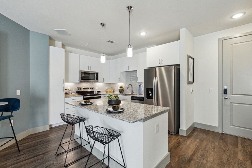 the residence on lamar apartment kitchens with granite counter tops and stainless steel appliances at LynnCora, Grand Prairie