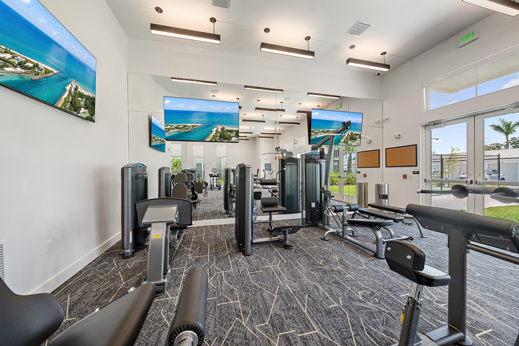 A gym with a variety of equipment including treadmills, weights, and exercise machines. at Mira at Palmer Ranch, Florida