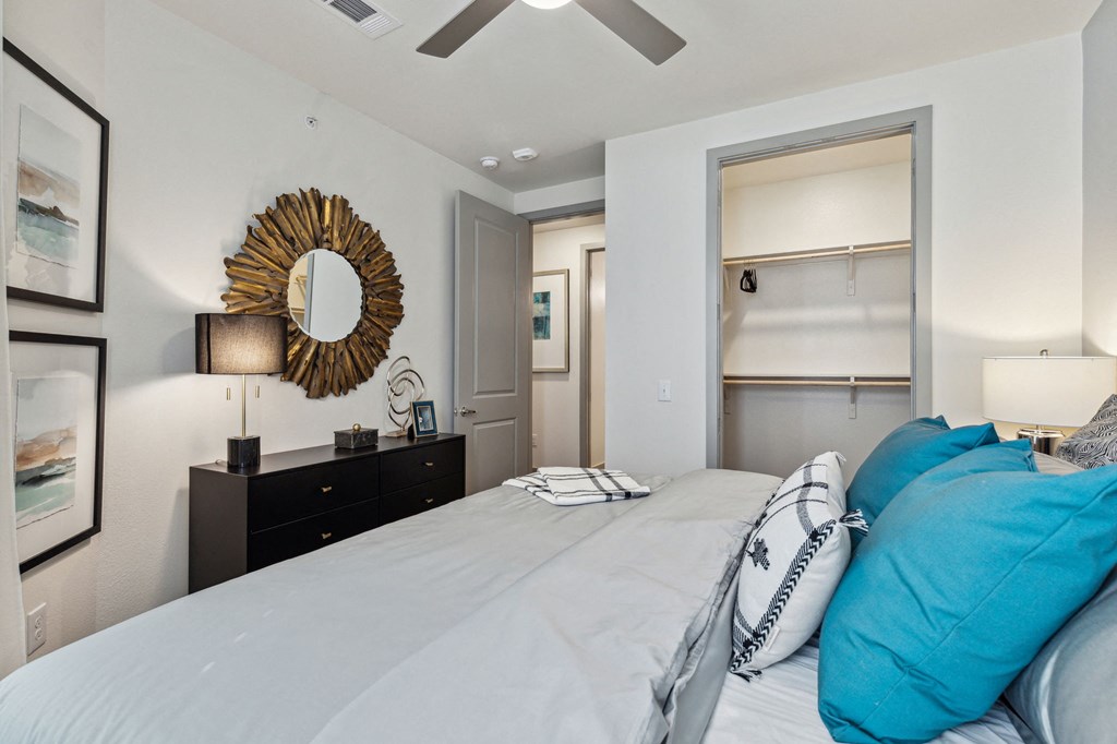 a bedroom with a large bed and a mirror on the wall with ceiling fan at LynnCora, Grand Prairie, TX