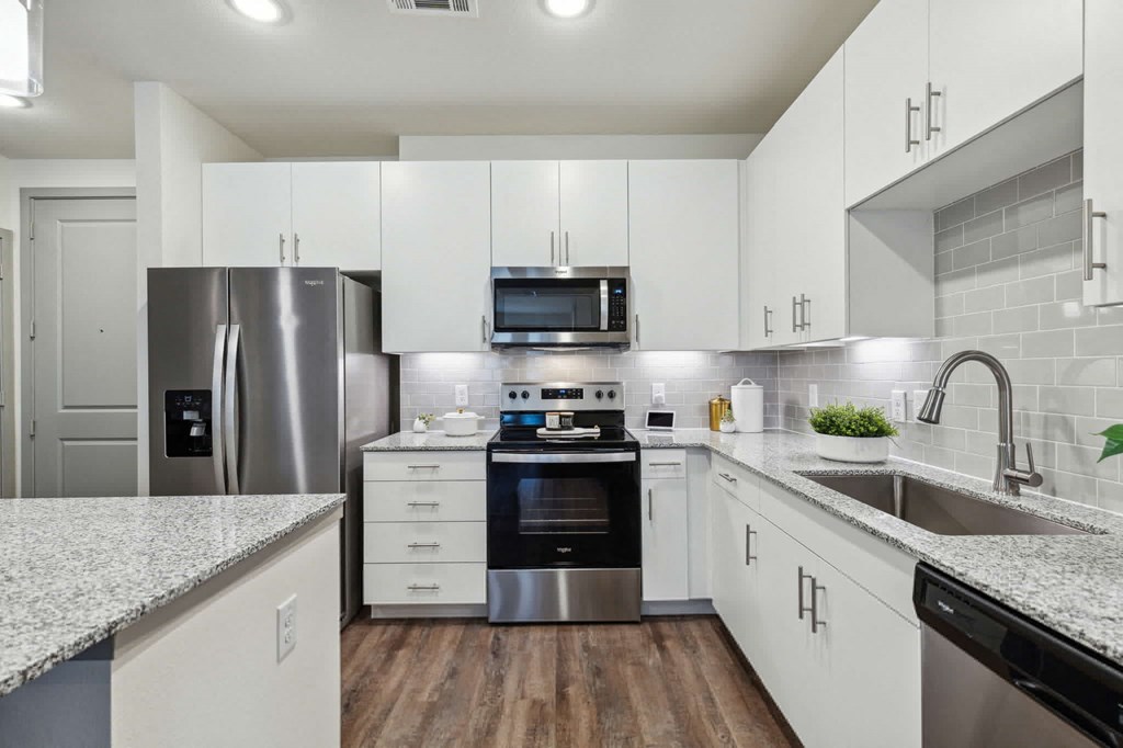 an empty kitchen with white cabinets and stainless steel appliances at LynnCora, Texas