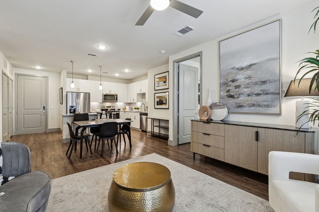 a living room and kitchen with a dining room table and chairs at LynnCora, Grand Prairie, TX